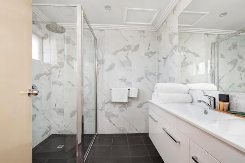 a bathroom with a shower and a sink at Sunseeker Motor Inn in Batemans Bay