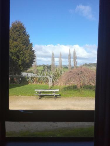 a picnic table sitting in a park with a window at JunoHall Backpackers in Waitomo Caves