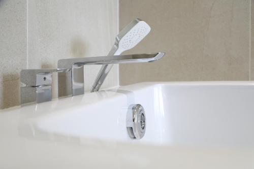 a bath tub with a sink with a toothbrush at Dai Viet Hotel in Thanh Hóa