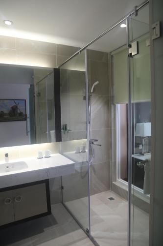 a bathroom with a glass shower and a sink at Dai Viet Hotel in Thanh Hóa