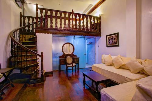 a living room with a couch and a staircase at Hotel Luna in Vigan