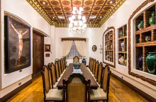 a dining room with a long table and chairs at Hotel Luna in Vigan