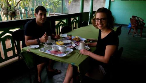 a man and a woman sitting at a table eating food at Lagoon Inn in Hambantota