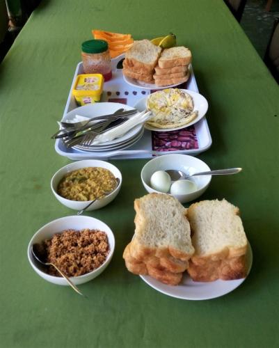 a table topped with plates of bread and bowls of food at Lagoon Inn in Hambantota