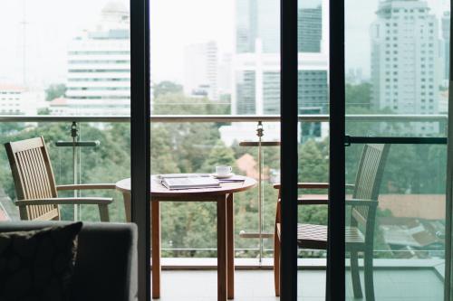 a table and two chairs in a room with a window at JW Marriott Hotel & Suites Saigon, The Apartments in Ho Chi Minh City