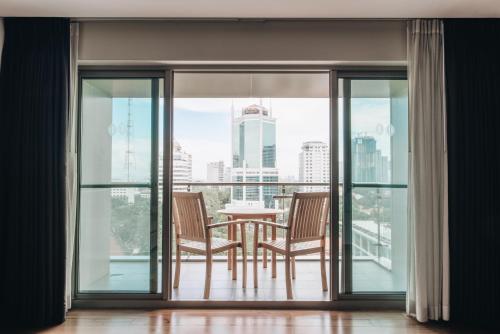 a balcony with a table and chairs and a view of the city at JW Marriott Hotel & Suites Saigon, The Apartments in Ho Chi Minh City