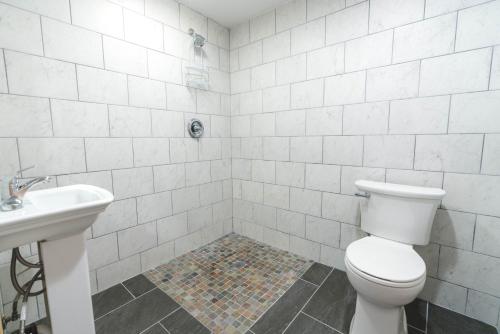 a white bathroom with a toilet and a sink at Cache Cabins in Sunshine