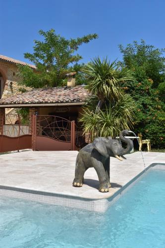 a statue of an elephant standing next to a swimming pool at Mas d'Asvin & Spa in Saint-Christol-lès-Alès