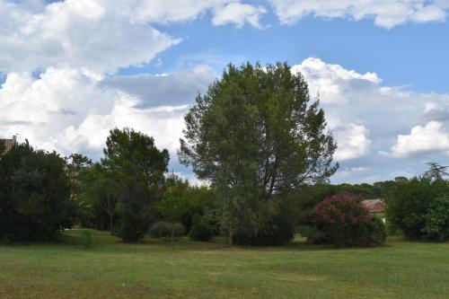 a field with trees and a sky with clouds at Mas d'Asvin & Spa in Saint-Christol-lès-Alès