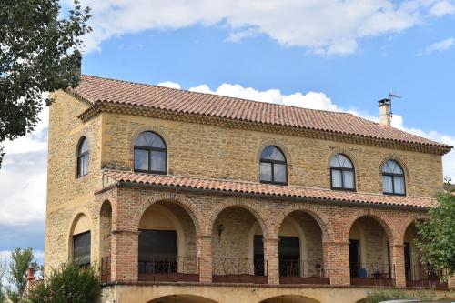 a brick building with windows and a roof at Mas d'Asvin & Spa in Saint-Christol-lès-Alès