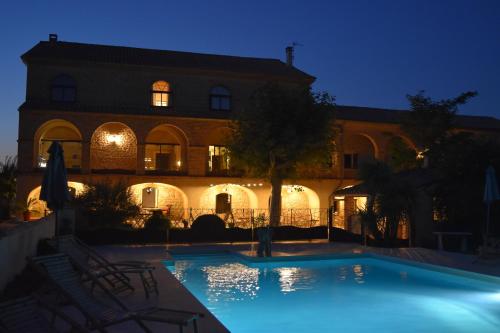 a swimming pool in front of a building at night at Mas d'Asvin & Spa in Saint-Christol-lès-Alès