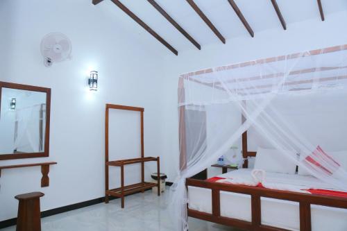 a bedroom with a bed with a mosquito net at Sigiri Mango Garden Resort in Sigiriya