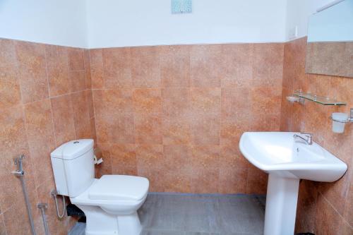 a bathroom with a toilet and a sink at Sigiri Mango Garden Eco Resort in Sigiriya
