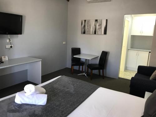 a hotel room with a bed with a stuffed animal on a towel at Hideaway Motor Inn in Armidale
