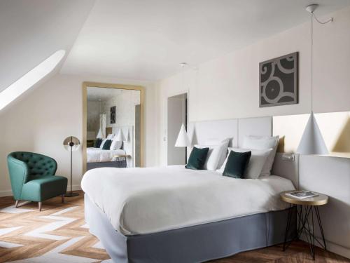 Кровать или кровати в номере Le Louis Hotel Versailles Château - MGallery Collection