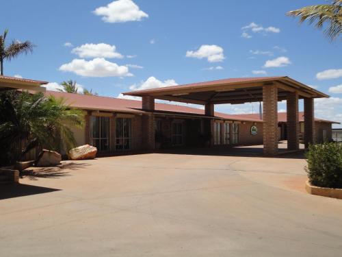 a large white building with a canopy on top of it at The Lodge Motel in South Hedland