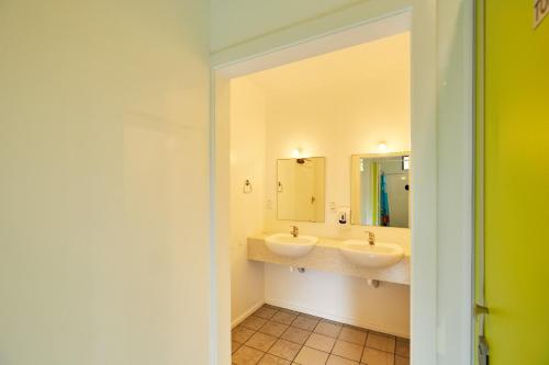 Baño con 2 lavabos y espejo en Dolphin Lodge, en Kaikoura