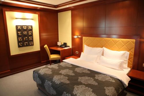 a hotel room with a bed and a desk at Garni Hotel Aleksandar in Novi Sad