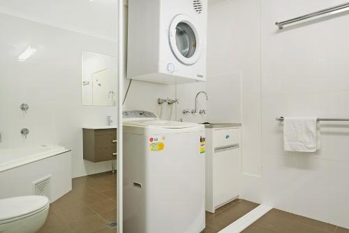 a white bathroom with a sink and a toilet at Albacore Apartments in Merimbula