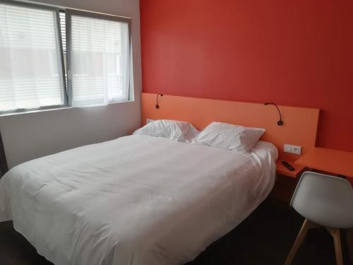 a bedroom with a white bed and a red wall at Atao Residence- Rennes Sud in Vern-sur-Seiche