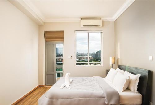 a bedroom with a bed with a white dog on it at MekongView 1 CondoTel in Phnom Penh