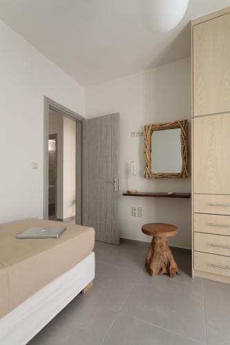 a bedroom with a bed and a wooden stool at Sweet Home Naxos in Naxos Chora
