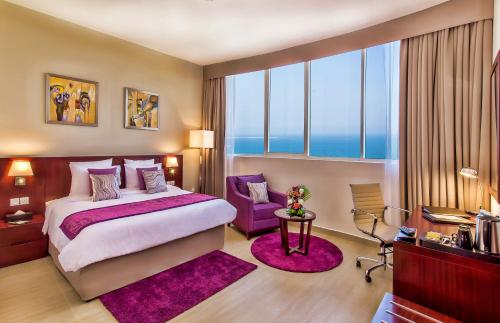 フジャイラにあるV Hotel Fujairahのベッドルーム1室(大型ベッド1台、紫色のラグ付)