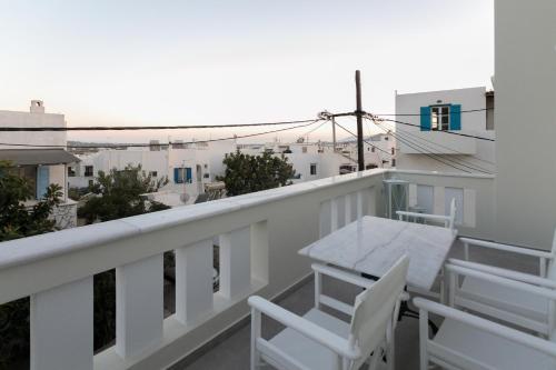 a balcony with white chairs and a table and a view at Sweet Home Naxos in Naxos Chora