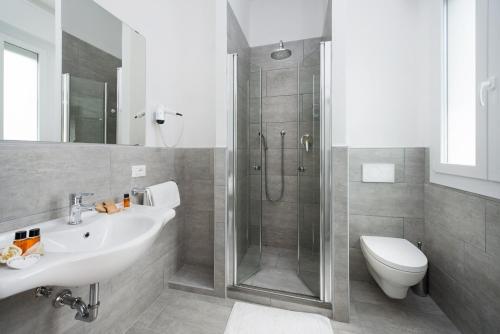 a bathroom with a shower and a sink and a toilet at Hotel Flora in Cesenatico