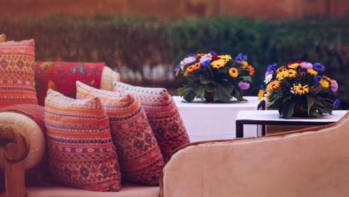 a group of pillows sitting on a table with flowers at Suryagarh Jaisalmer in Jaisalmer
