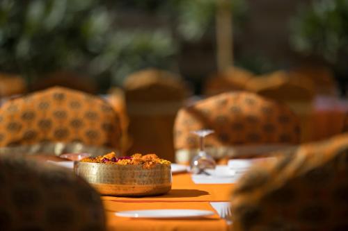 a table with a bowl of food on top of it at Suryagarh Jaisalmer in Jaisalmer