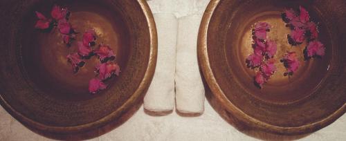 two brown plates with pink flowers on a table at Suryagarh Jaisalmer in Jaisalmer