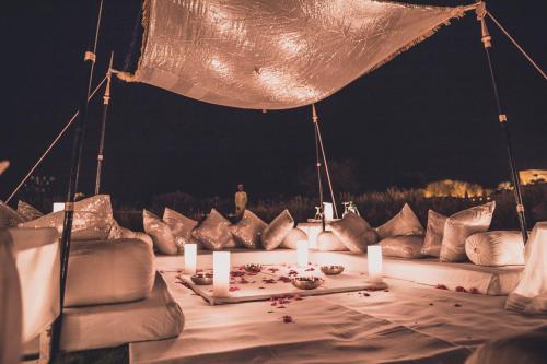 a table with candles on a couch with pillows at Suryagarh Jaisalmer in Jaisalmer