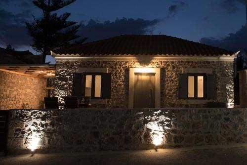 a house with lights in front of it at night at Calme Suites Mani in Agios Nikolaos