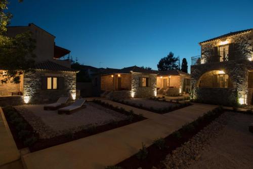a house with a patio at night with lights at Calme Suites Mani in Agios Nikolaos