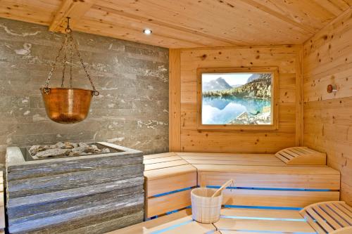 a sauna with a tub in a wooden cabin at Hotel Rosatsch in Pontresina