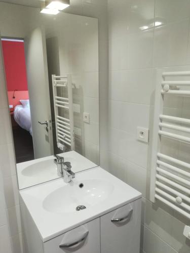 a white bathroom with a sink and a mirror at Atao Residence- Rennes Sud in Vern-sur-Seiche