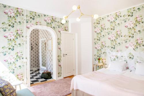a bedroom with a bed and floral wallpaper at Hotell Park in Västervik