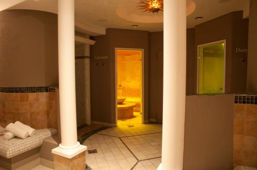 a bathroom with columns and a shower with a toilet at Hotel Rosatsch in Pontresina