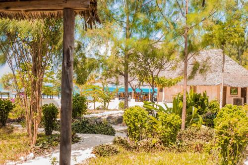 a view of a resort with trees and a building at Jaribu Beach Hotel in Paje