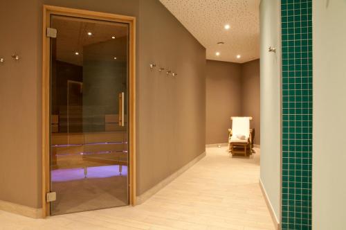 a hallway with a mirror and a chair in a room at Hotel Rosatsch in Pontresina