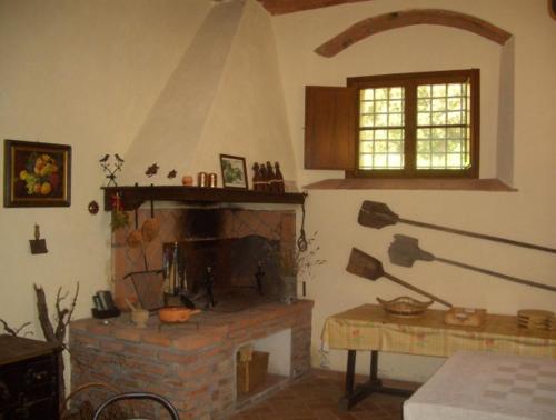 a living room with a brick fireplace and a window at Agriturismo Lupo Vecchio in Grosseto