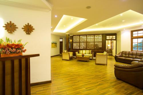 a lobby with couches and chairs and a table at Heaven Seven Nuwara Eliya in Nuwara Eliya