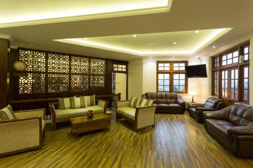 a living room with couches and chairs and a tv at Heaven Seven Nuwara Eliya in Nuwara Eliya