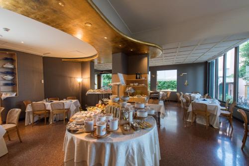 a dining room with white tables and chairs at Hotel Villa Mabapa in Venice-Lido