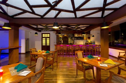 a restaurant with wooden tables and chairs and a bar at Heaven Seven Nuwara Eliya in Nuwara Eliya