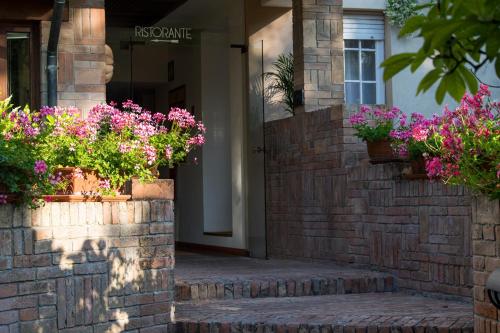 a building with flowers inpots on a brick wall at Hotel Villa Mabapa in Venice-Lido