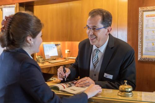 a man and a woman sitting at a desk at Hotel Villa Mabapa in Venice-Lido