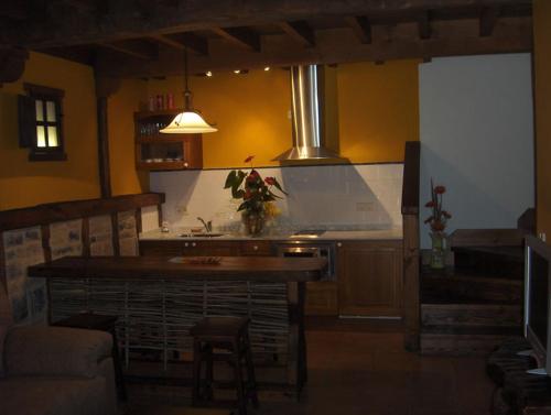 a kitchen with a island in the middle of a room at La Prida Apartamentos Rurales in Caleao
