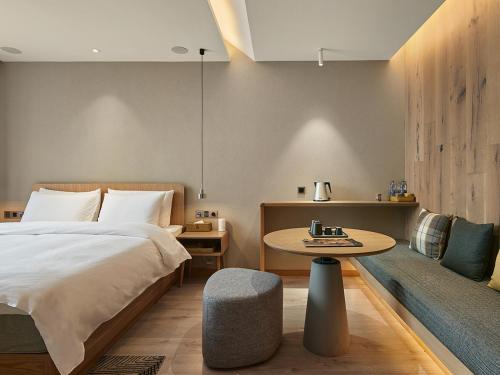 a bedroom with a bed and a table at EBO Hotel Hangzhou Wulin - 5 mins drive to the West Lake in Hangzhou